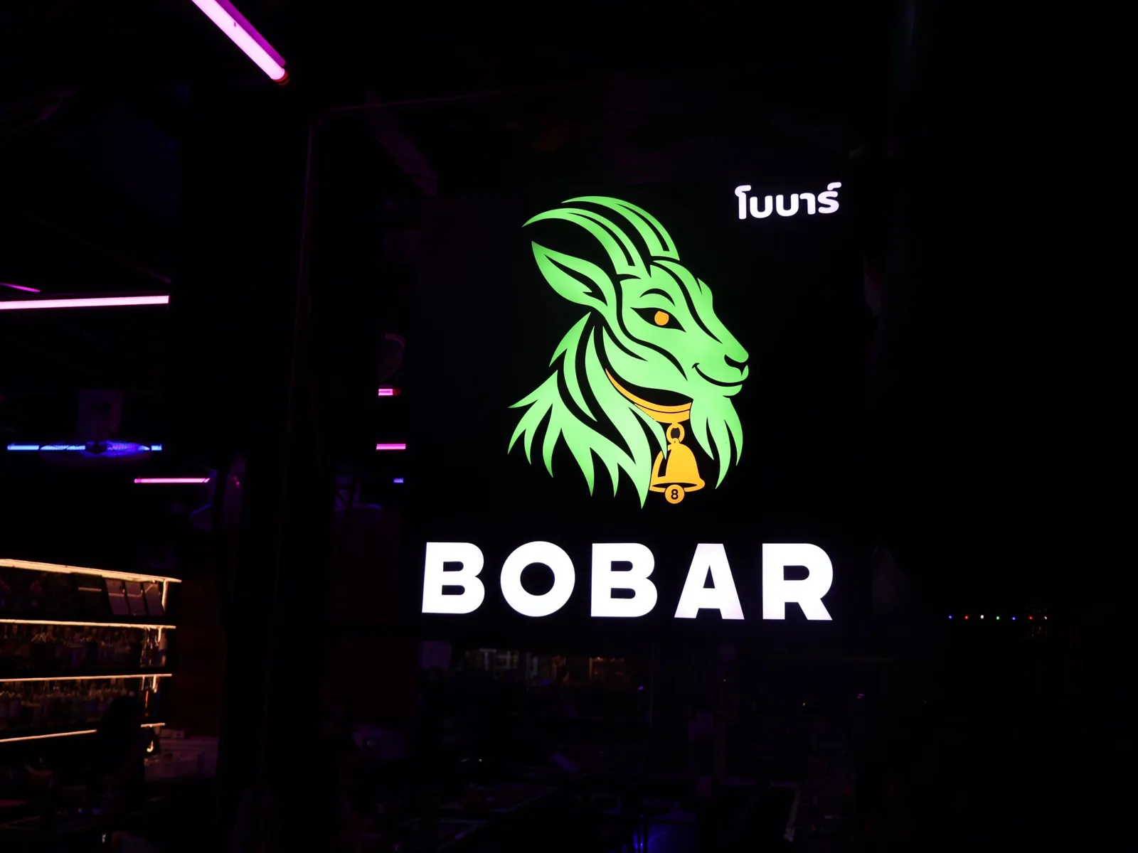 The illuminated BoBar sign with the green goat logo